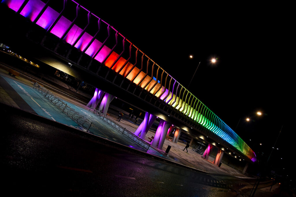Sillan valot loistavat sateenkaarenväreissä pimeässä.