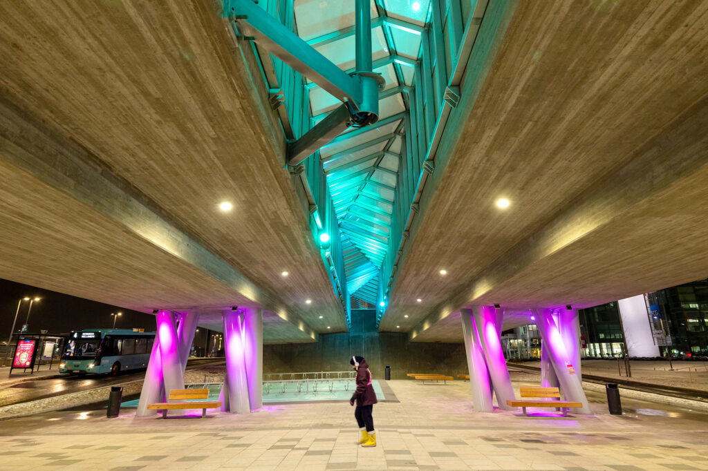 Sillan alikulussa loistavat pinkit ja turkoosit valot.