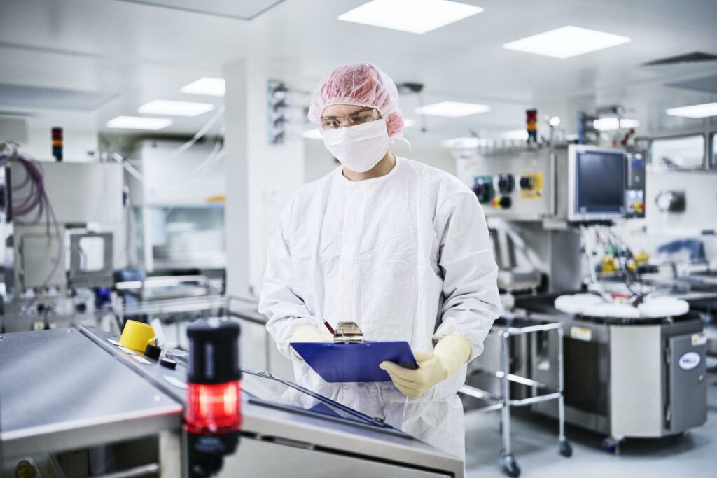 Suojavaatteisiin pukeutunut henkilö työskentelee laboratoriossa.