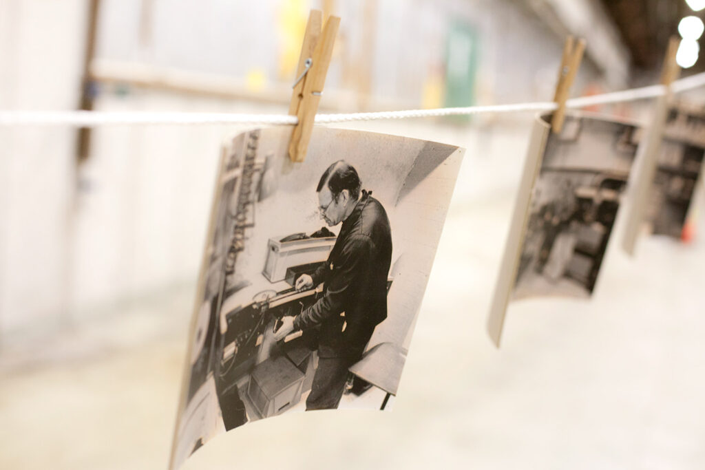 Vanhoja mustavalkoisia valokuvia roikkuu narulla pyykkipojilla ripustettuina.