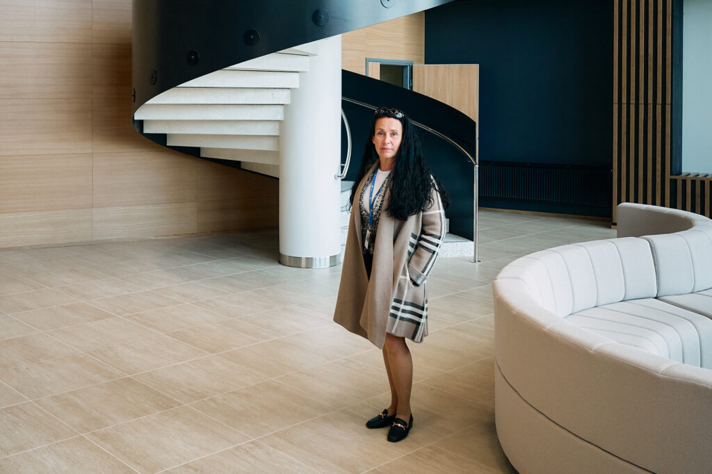 Nainen seisoo portaiden edessä ja katsoo kohti.