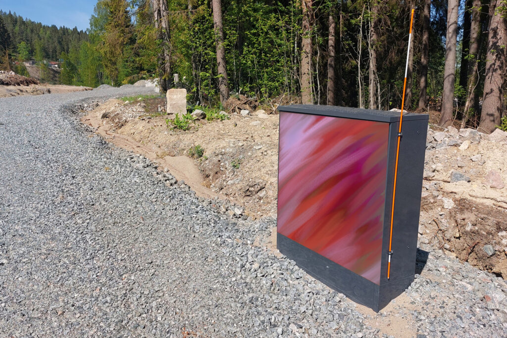 Sähkökaapin kyljessä punainen taideteos.