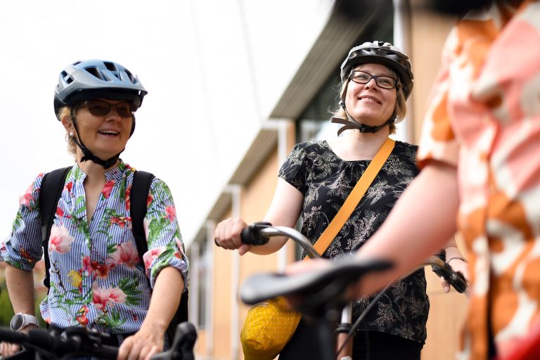 Kaksi pyöräilijää juttelee iloisesti.