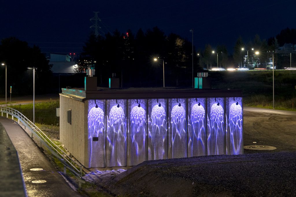 Vedenpumppaamon seinäpinnalla välkehtii veden heijastuksia muistuttava valokuvio.